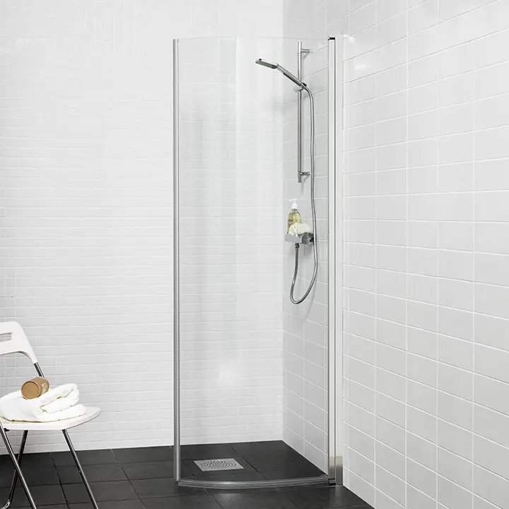 Moderne og lett buet dusjdør med elegante kromfargede profiler.